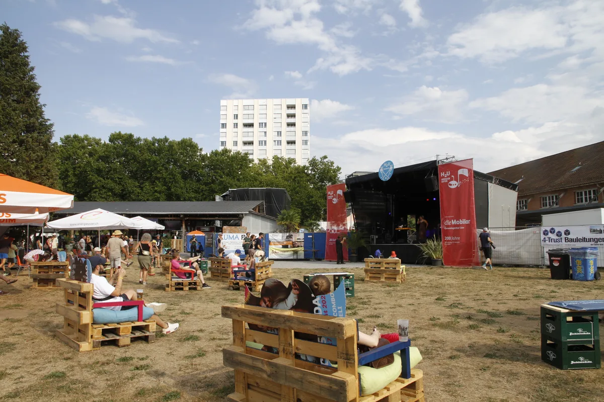 Eine Band spielt auf einer kleinen Bühne vor wenig  Publikum.